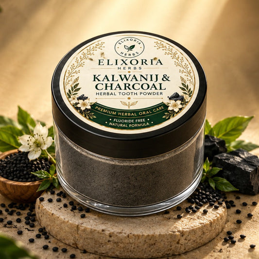 A jar of Elixiria Herbs Kalwanji & Charcoal Herbal Tooth Powder sits on a stone pedestal surrounded by leaves, black peppercorns, a small bowl of black powder, and a piece of charcoal, set against a warm sandy background with dappled sunlight.